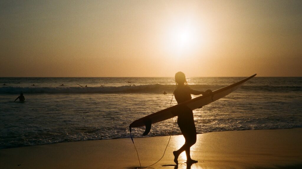 Surferin am Strand von Bali bei Sonnenuntergang