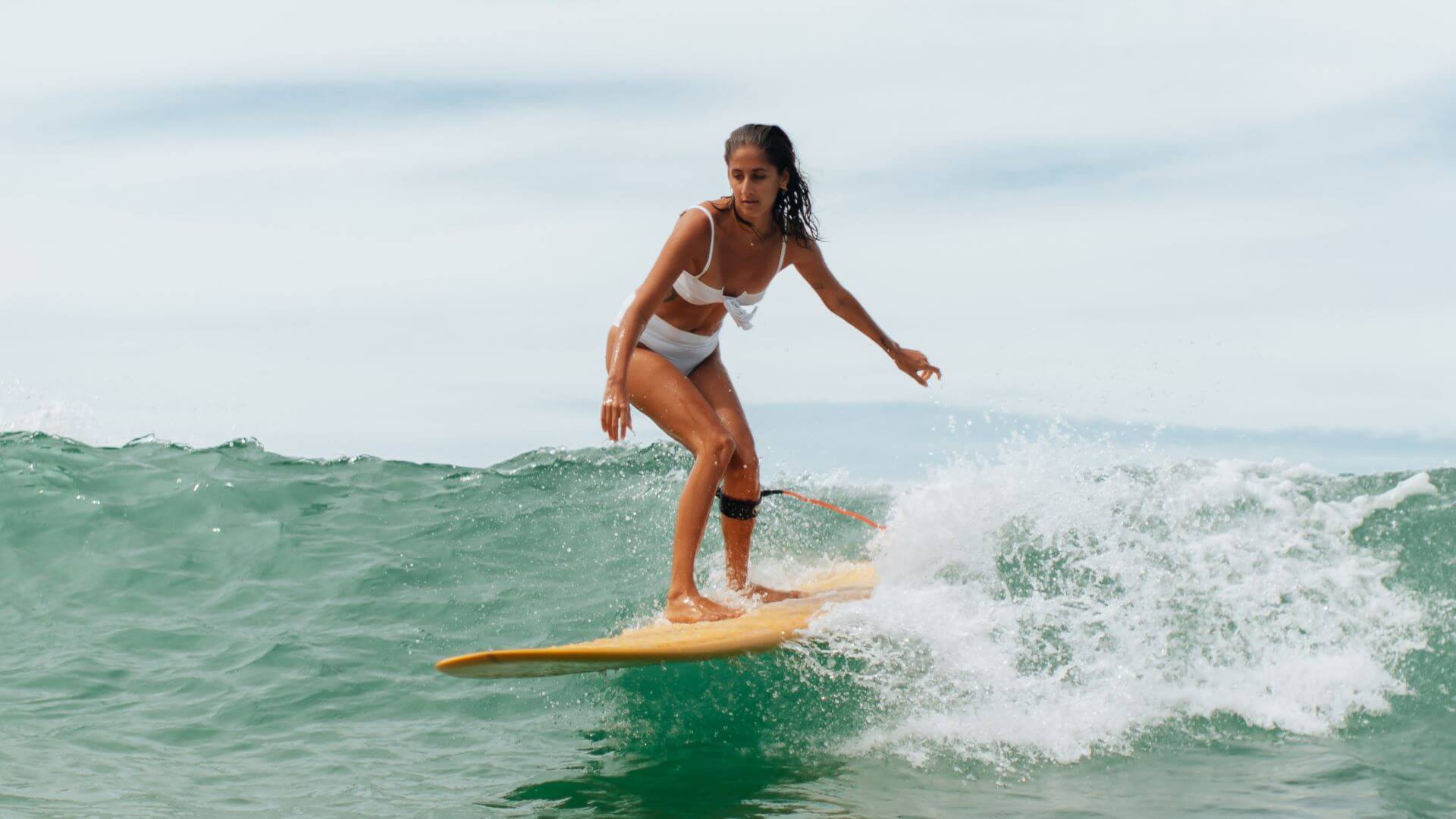 Surferin auf Grüner Welle auf Bali
