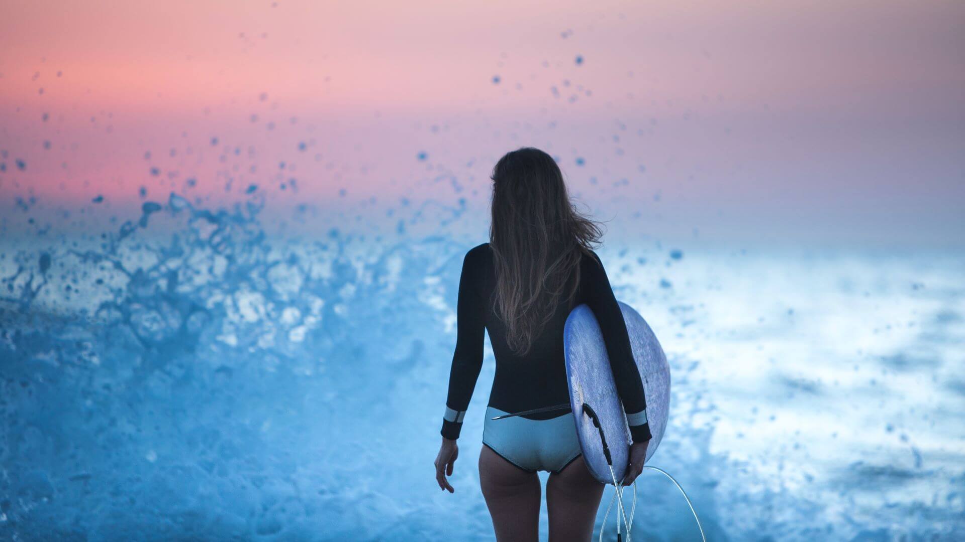 Surfer Girl am Strand von Bali bei Sonnenuntergang